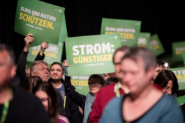 Delegierte mit Schildern auf Parteitag 